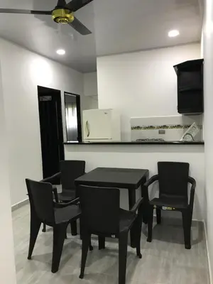 a dining room with a black table and chairs at Apartahotel in Doradal