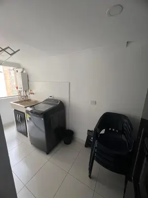 a living room with a tv and a chair at Apartamento Medellín in Medellín