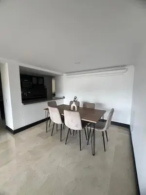 a dining room with a wooden table and chairs at Apartamento Medellín in Medellín