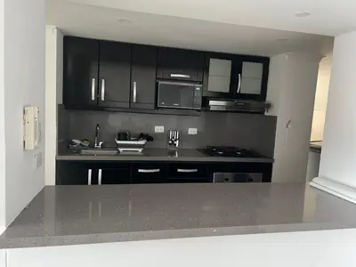 a kitchen with black cabinets and a counter top at Apartamento Medellín in Medellín