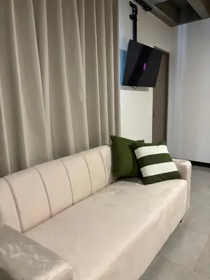 a white couch with green and white pillows on it at Moore 45 Tu Espacio Comodo en Medellín in Medellín