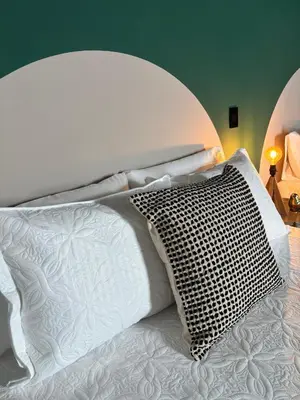 a white bed with a black and white pillow at Moore 45 Tu Espacio Comodo en Medellín in Medellín