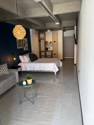 a bedroom with a bed and a couch and a table at Moore 45 Tu Espacio Comodo en Medellín in Medellín
