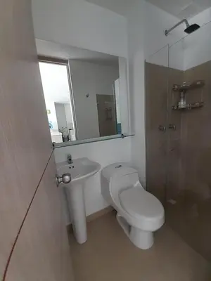 a bathroom with a toilet and a sink and a mirror at Agradable y confortable apto vacacional en Santa Fé de Antioquia-Colombia dentro de condominio con piscina, tobogán, zonas recreativas, jardines y espectacular vista in Santa Fe de Antioquia