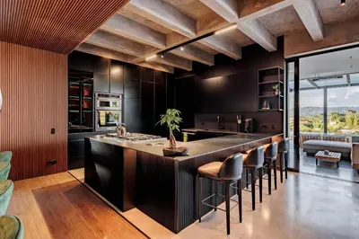 a kitchen with black walls and a bar with stools at Luxurious Farm House Finca Libia in Guarne