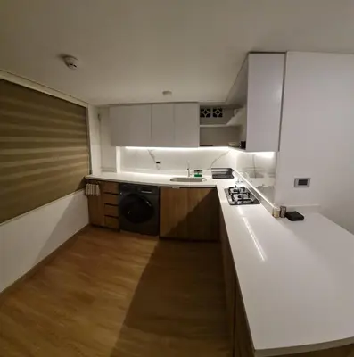 a kitchen with white cabinets and a washer and dryer at Nomad Studio el Cable in Manizales