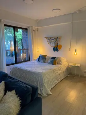 a bedroom with a bed and a couch and a window at Loft moderno en el Poblado con Aire acondicionado in Medellín