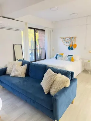 a blue couch in a living room with a bed at Loft moderno en el Poblado con Aire acondicionado in Medellín