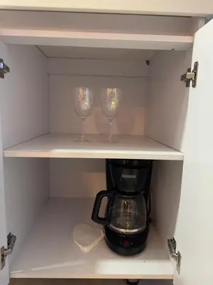 a cupboard with two wine glasses and a coffee maker at Loft moderno en el Poblado con Aire acondicionado in Medellín