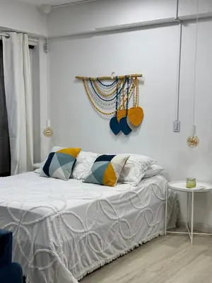 a white bedroom with a bed with pillows on it at Loft moderno en el Poblado con Aire acondicionado in Medellín