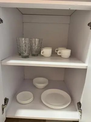 a white shelf with plates and cups on it at Loft moderno en el Poblado con Aire acondicionado in Medellín