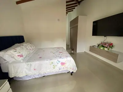 a bedroom with a bed and a flat screen tv at Las Flores de María 302 in Jardin