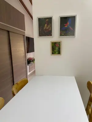 a room with a white table and three paintings on the wall at Las Flores de María 302 in Jardin