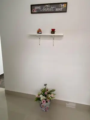 a white wall with a shelf and a vase of flowers at Las Flores de María 302 in Jardin