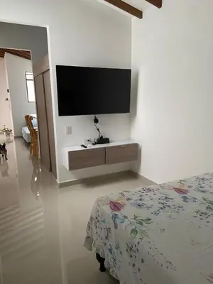 a bedroom with a bed and a tv on a wall at Las Flores de Mria 303 in Jardin