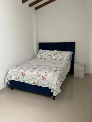 a bedroom with a bed with a blue headboard at Las Flores de Mria 303 in Jardin