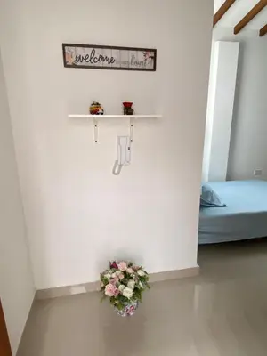 a room with a bed and a shelf with flowers at Las Flores de Mria 304 in Jardin