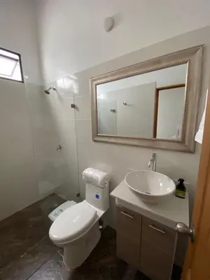 a bathroom with a toilet and a sink and a mirror at Las Flores de Mria 304 in Jardin