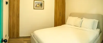 a bedroom with a bed with white sheets and pillows at Loft Moderno junto al Monasterio de Jericó in Jericó