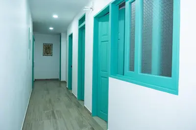 a hallway with green doors and wooden floors at Loft Moderno junto al Monasterio de Jericó in Jericó