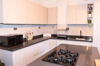 a kitchen with white cabinets and a stove top oven at Loft Moderno junto al Monasterio de Jericó in Jericó