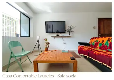 a living room with a red couch and a table at Casas confortable Laureles in Medellín