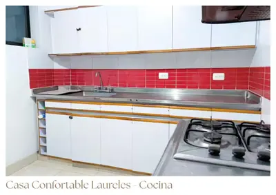 a kitchen with white cabinets and a sink and a stove at Casas confortable Laureles in Medellín