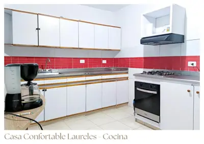 a kitchen with white cabinets and red tiles at Casas confortable Laureles in Medellín