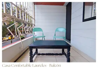 two chairs sitting on a porch with a table at Casas confortable Laureles in Medellín