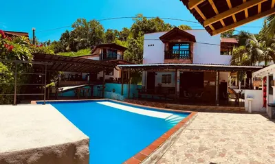 a swimming pool in front of a house at Hotel Kapla in San Rafael