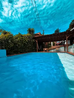 a swimming pool with blue water in front of a house at Hotel Kapla in San Rafael