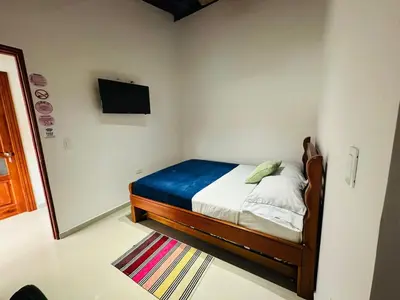 a bedroom with a bed and a tv on the wall at Hotel Jardin de Rosas in Jardin