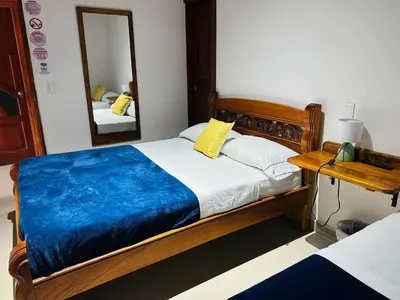 a bedroom with a bed and a mirror at Hotel Jardin de Rosas in Jardin