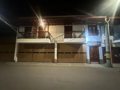 a building with two balconies and a gate at night at Hotel Jardin de Rosas in Jardin
