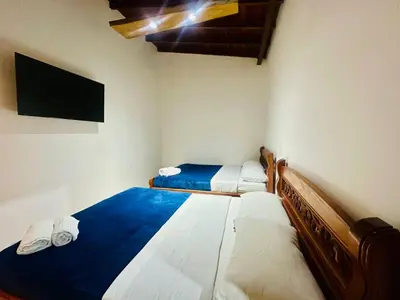 two beds in a small room with a television at Hotel Jardin de Rosas in Jardin