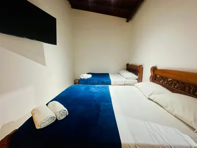a room with two beds and a flat screen tv at Hotel Jardin de Rosas in Jardin