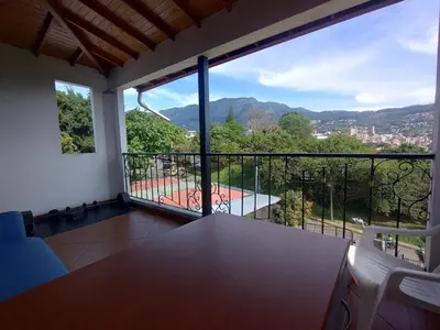 a room with a balcony with a view of a city at Apartamento Vista Hermosa En la Mitad de Medellín in Medellín