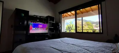 a bedroom with a bed and a tv and a window at Apartamento Vista Hermosa En la Mitad de Medellín in Medellín