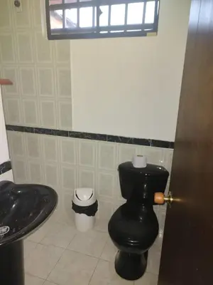 a bathroom with a black toilet and a sink at Apartamento Vista Hermosa En la Mitad de Medellín in Medellín