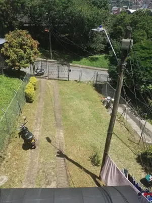 a scooter parked on the grass next to a street light at Apartamento Vista Hermosa En la Mitad de Medellín in Medellín