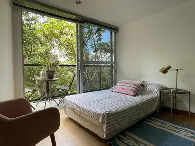 a bedroom with a bed and a large window at Modern & Calm Stay Near Provenza in Medellín