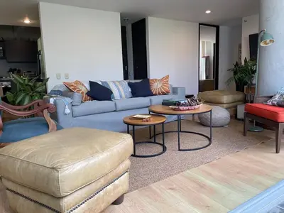 a living room with a blue couch and a table at Modern & Calm Stay Near Provenza in Medellín