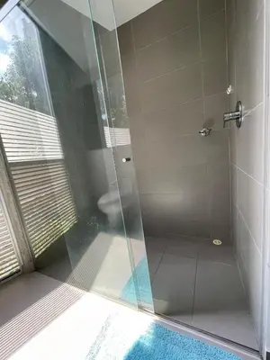 a bathroom with a glass shower with a toilet at Modern & Calm Stay Near Provenza in Medellín