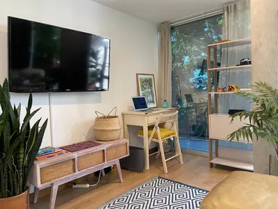 a living room with a desk and a tv on a wall at Modern & Calm Stay Near Provenza in Medellín