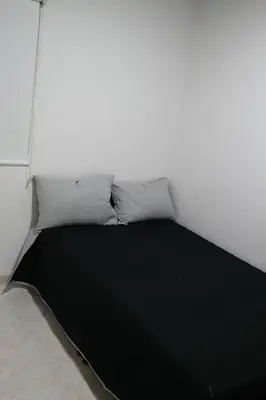 a bed in a white room with two pillows at Single studio apartment 4 in Medellín