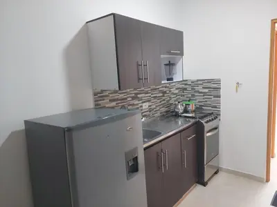 a kitchen with gray cabinets and a sink and a stove at Single studio apartment 4 in Medellín