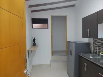 a kitchen with a door leading into a room at Single studio apartment 4 in Medellín
