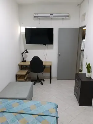 a bedroom with a desk and a chair and a television at individual studio apartment 3 in Medellín
