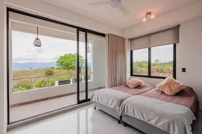 a bedroom with a bed and large windows at Luxury Villa in Cerritos ride horses nearby in Pereira