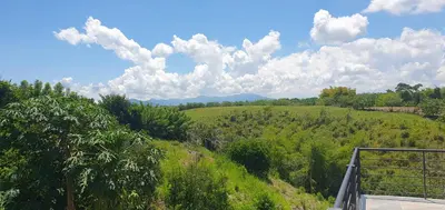 a view of a green hill with trees and clouds at Luxury Villa in Cerritos ride horses nearby in Pereira
